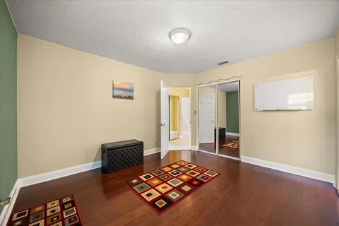 a bedroom with a bed and wooden floor