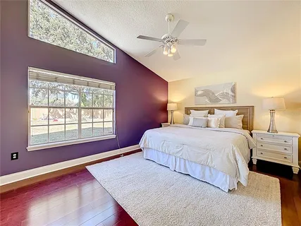 a bedroom with a large bed and a chandelier