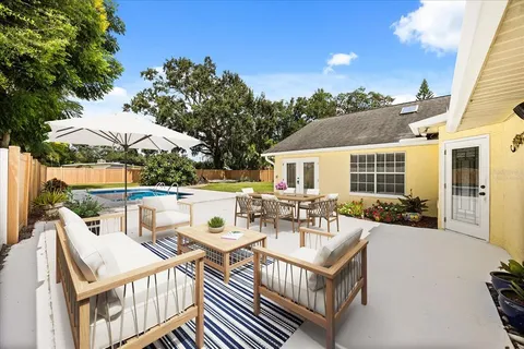 a view of a patio with couches table and chairs and potted plants