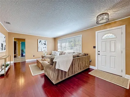 a living room with furniture and wooden floor