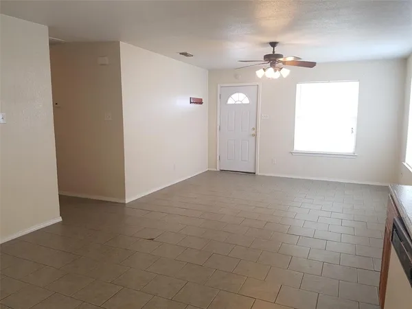 a view of an empty room with a chandelier fan