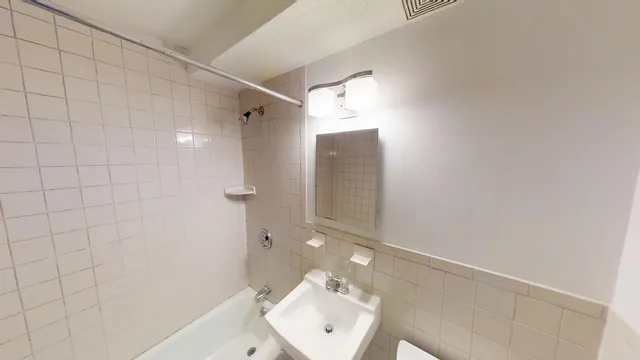 a bathroom with a sink mirror and shower