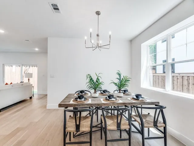 a dining room with furniture a chandelier and wooden floor