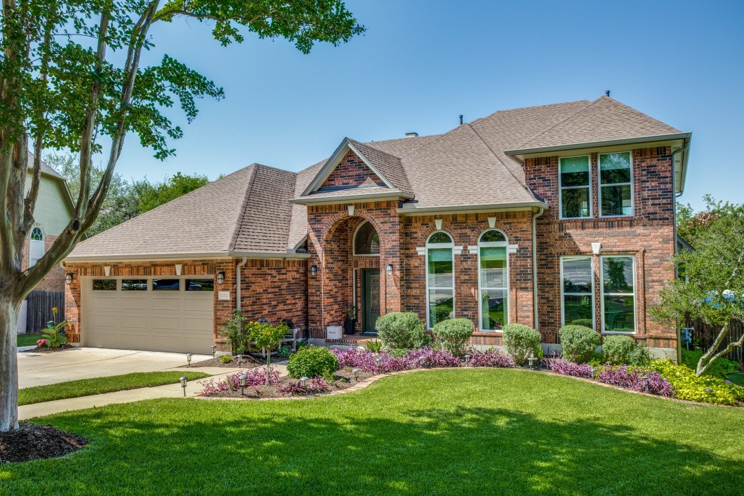 10322 Open Gate Drive Austin, TX 78726 - Photo 1 of 1 a front view of a house with a garden and plants