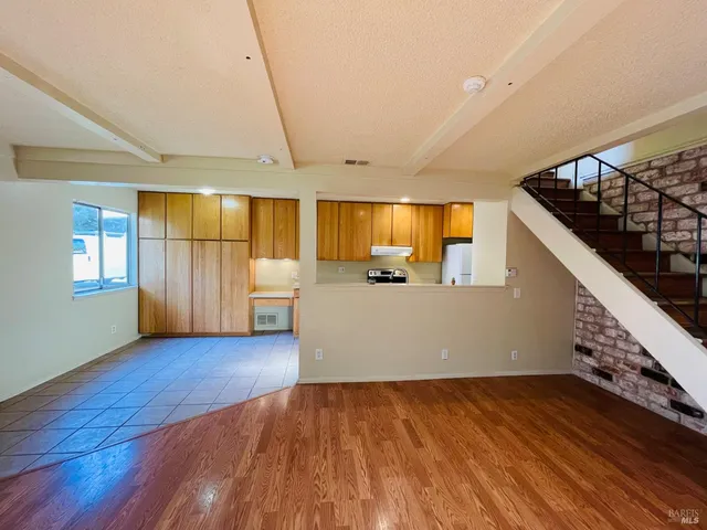 a view of a livingroom with wooden floor and staircase