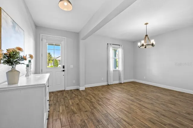 a view of empty room with wooden floor