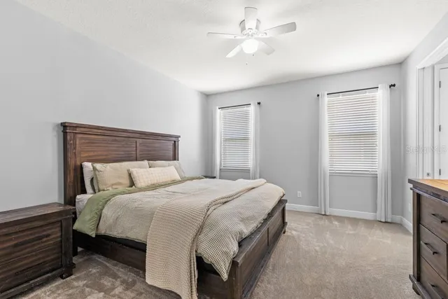a bedroom with a large bed and a ceiling fan