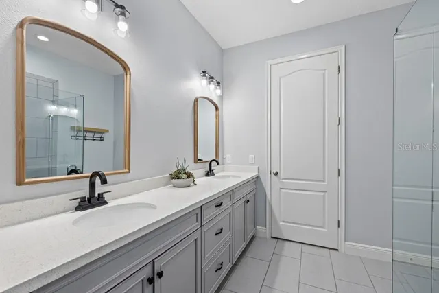 a bathroom with a double vanity sink mirror and