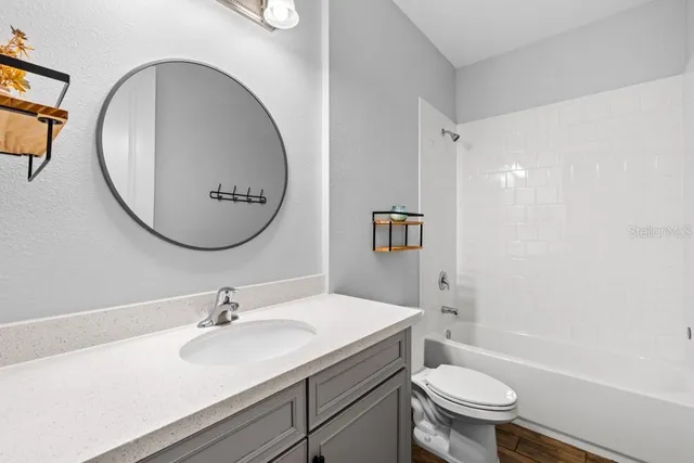 a bathroom with a sink toilet a mirror and tub