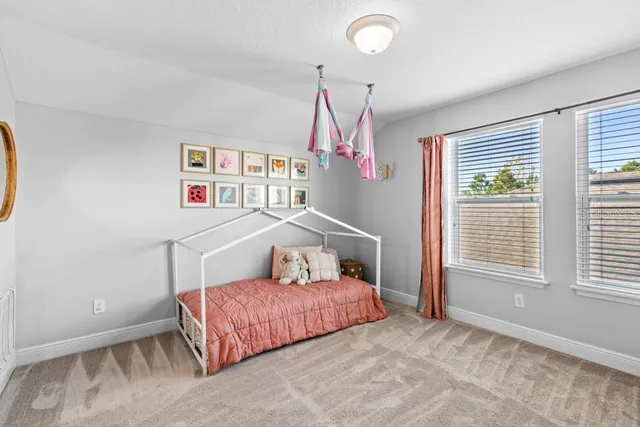 a bedroom with a bed next to a window and a potted plant on a dresser