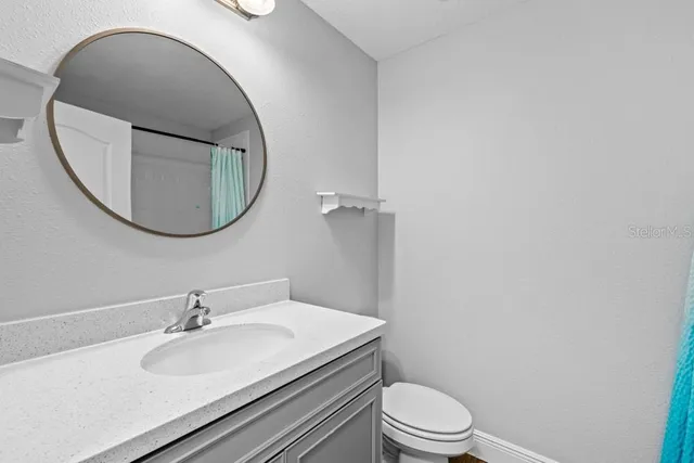 a bathroom with a sink a toilet and mirror