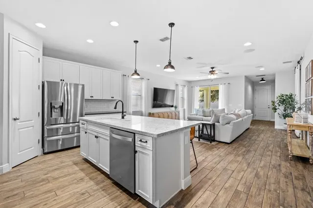 a kitchen with stainless steel appliances granite countertop a sink stove and refrigerator