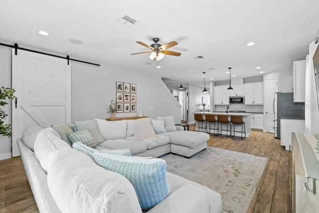 a living room with furniture kitchen view and a chandelier