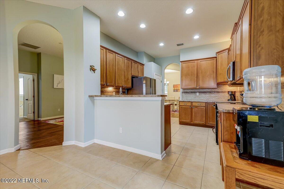 697 Porta Rosa Circle St. Augustine, FL 32092 - Photo 13 of 43 a kitchen with kitchen island granite countertop a sink counter top space appliances and cabinets