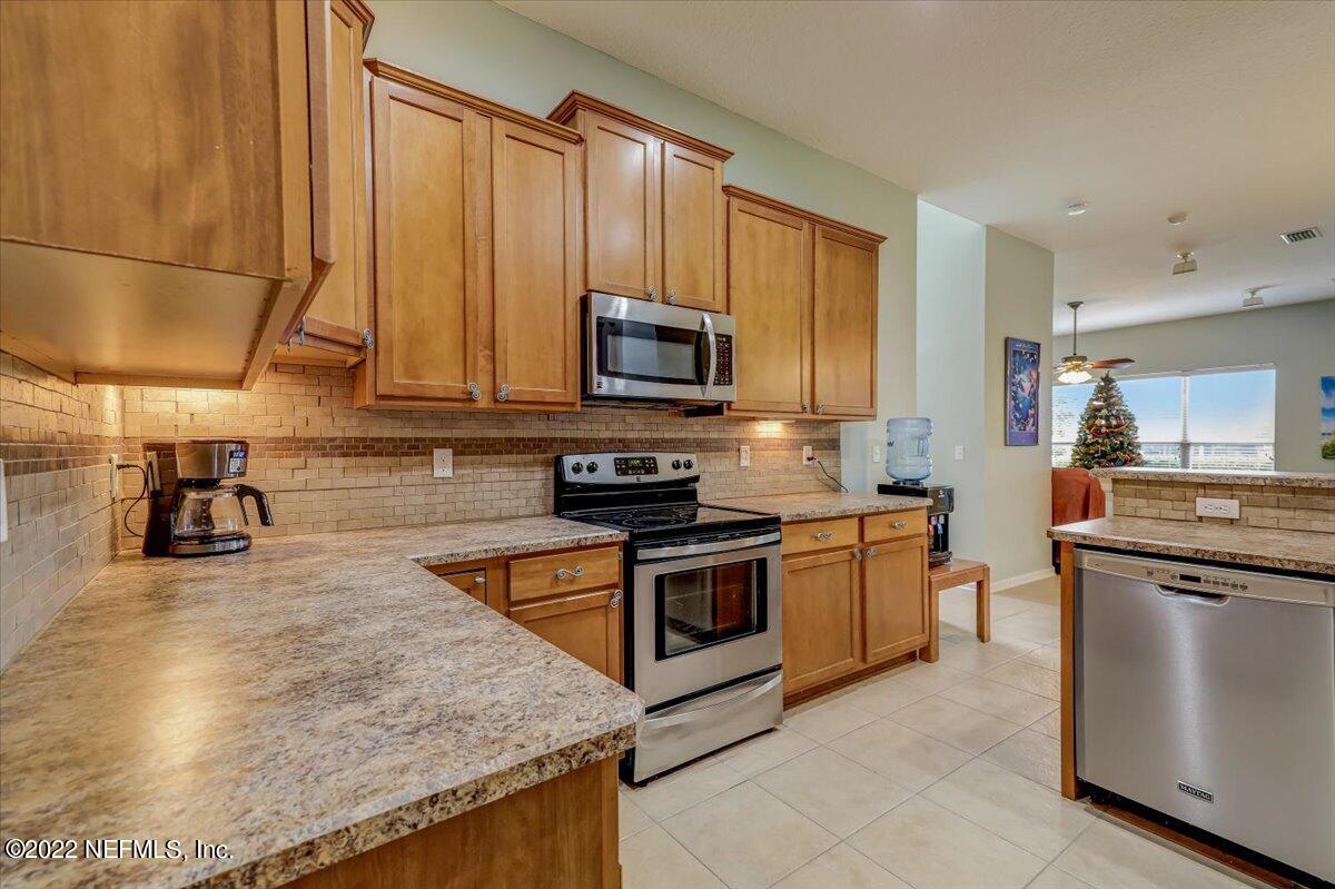 697 Porta Rosa Circle St. Augustine, FL 32092 - Photo 14 of 43 a kitchen with stainless steel appliances granite countertop a stove a sink and a microwave