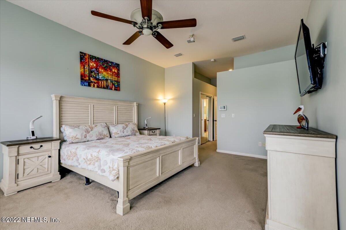 697 Porta Rosa Circle St. Augustine, FL 32092 - Photo 18 of 43 a spacious bedroom with a bed and a flat screen tv