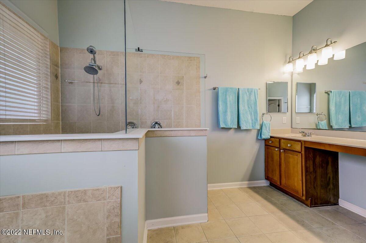 697 Porta Rosa Circle St. Augustine, FL 32092 - Photo 21 of 43 a bathroom with a double vanity sink a large mirror and a bathtub