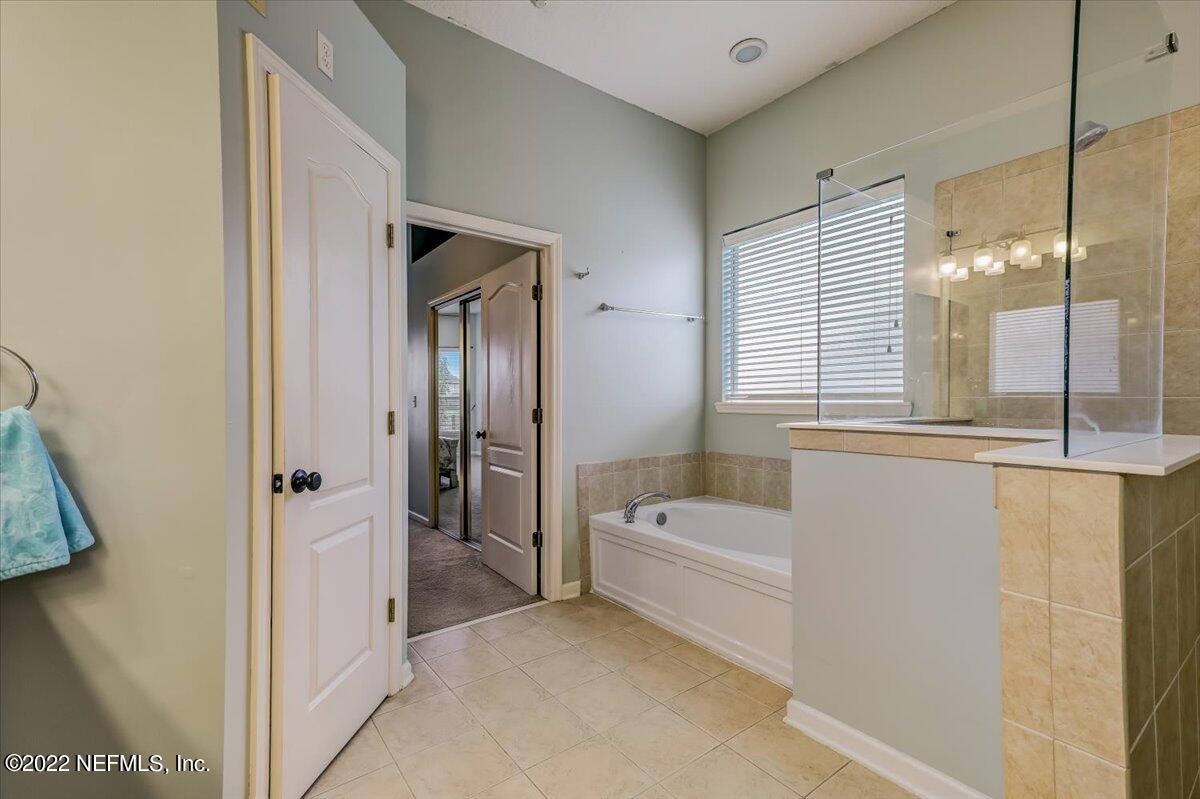 697 Porta Rosa Circle St. Augustine, FL 32092 - Photo 22 of 43 a bathroom with a tub a mirror and a shower