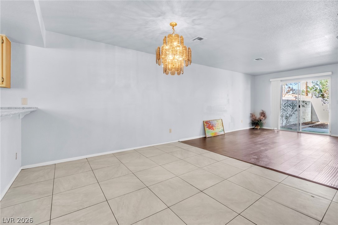 6250 West Flamingo Road, Unit 98 Las Vegas, NV 89103 - Photo 3 of 40 Spare room featuring an inviting chandelier, light tile patterned flooring, baseboards, and visible vents