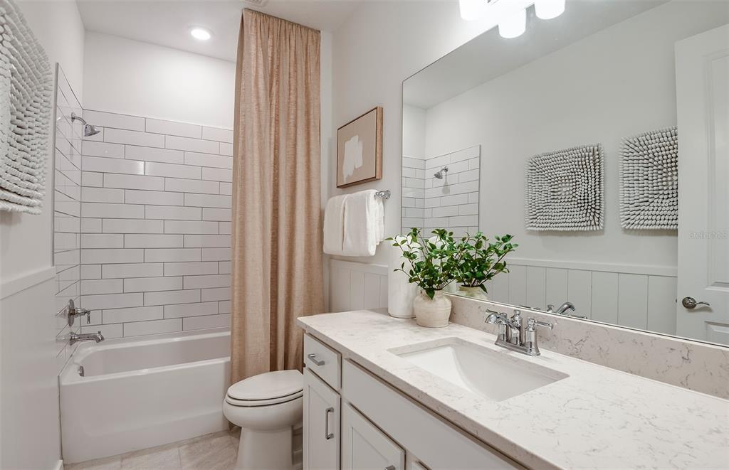 3768 Obsidian Drive Spring Hill, FL 34609 - Photo 17 of 24 a bathroom with a granite countertop sink a toilet a mirror a vanity and shower