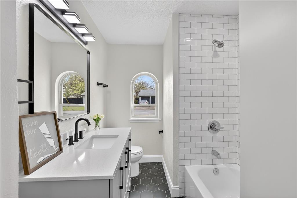 6425 Summit Ridge Drive Watauga, TX 76148 - Photo 12 of 18 New updated bathroom from the vanity with granite, new tile, new bathtub and new window. Everything is new even the fixtures and mirror