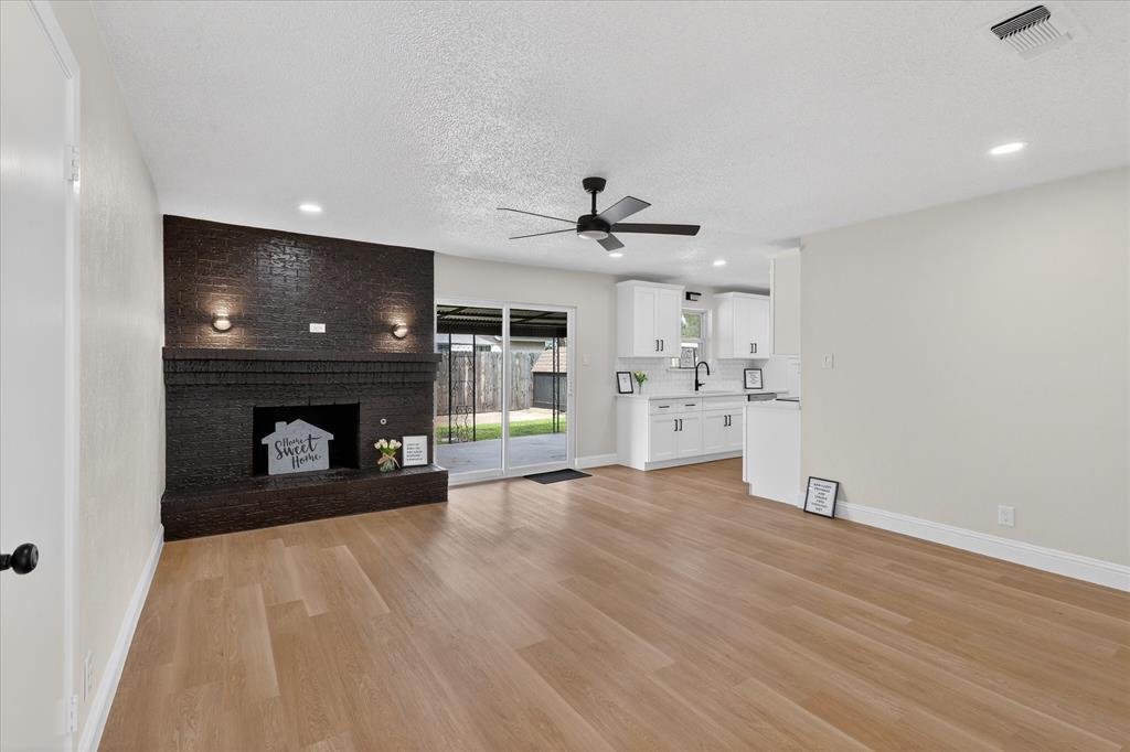 6425 Summit Ridge Drive Watauga, TX 76148 - Photo 3 of 18 Living room. Wood burning fireplace. New flooring. New lights and fixtures