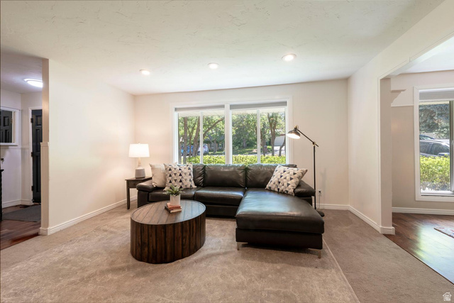 9676 Mt Jordan Road Sandy, UT 84092 - Photo 7 of 38 Spacious living area featuring neutral-toned walls, recessed lighting, and a large window