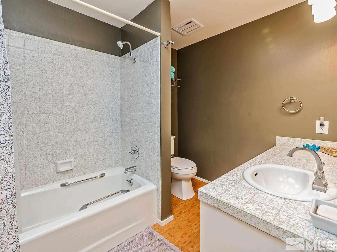 3447 Skyline Boulevard Reno, NV 89509 - Photo 19 of 24 a bathroom with a granite countertop sink toilet and shower