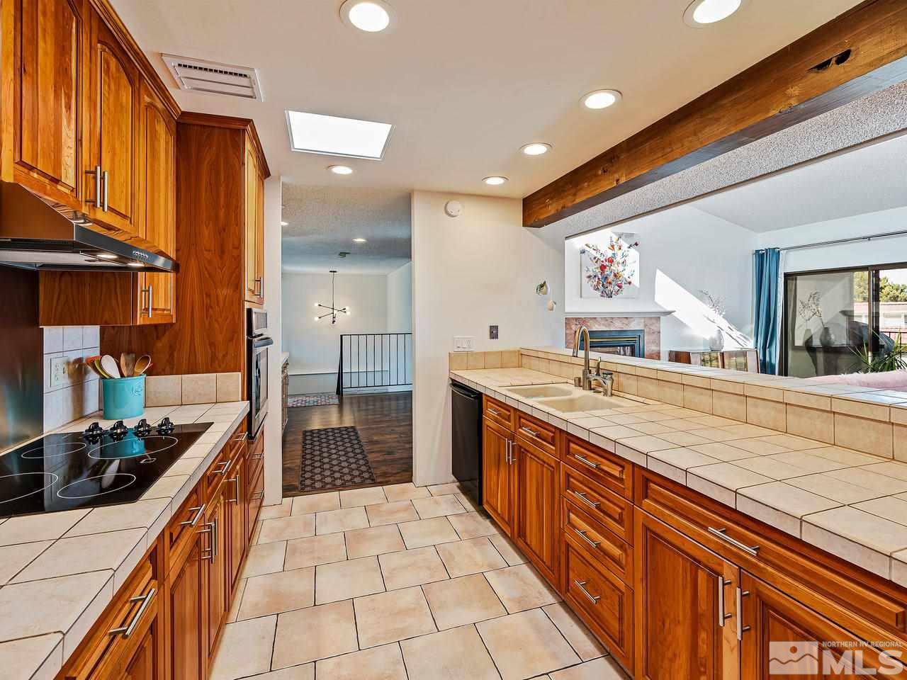 3447 Skyline Boulevard Reno, NV 89509 - Photo 10 of 24 a large kitchen with stainless steel appliances a large counter top a stove and a refrigerator