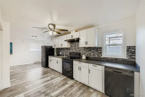 a kitchen with granite countertop a sink stainless steel appliances and cabinets