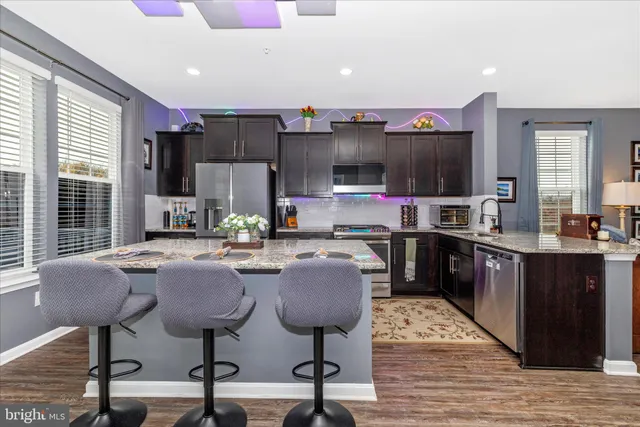 a kitchen with a stove a faucet a dining table and chairs