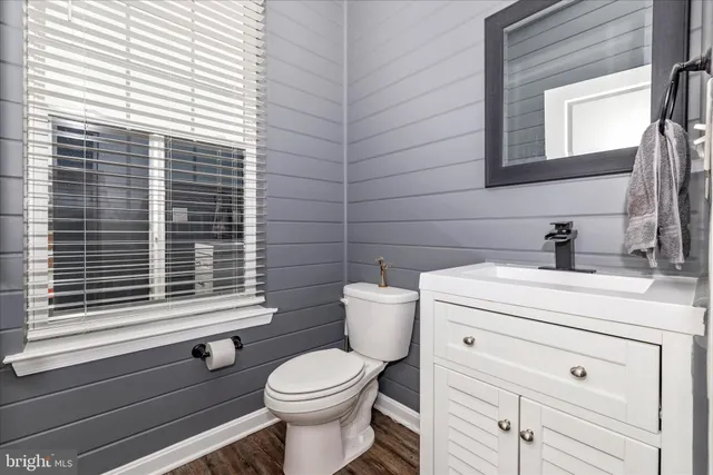 a bathroom with a granite countertop sink a mirror and shower