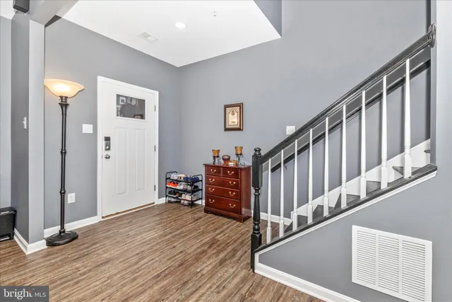 a view of a hallway with wooden floor and stairs