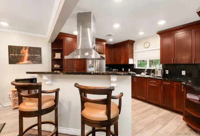 a kitchen with stainless steel appliances granite countertop a sink a stove a refrigerator cabinets and dining table