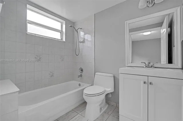 a bathroom with a bathtub shower sink vanity and a toilet