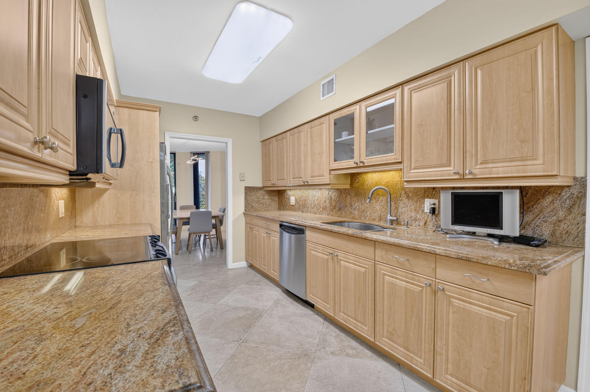 1401 South Ocean Boulevard, Unit 1060 Boca Raton, FL 33432 - Photo 13 of 46 a kitchen with stainless steel appliances granite countertop a stove a sink and a microwave