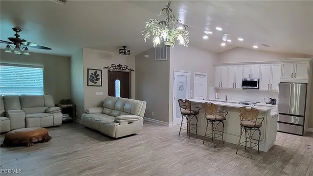 a living room with furniture a chandelier and a dining room