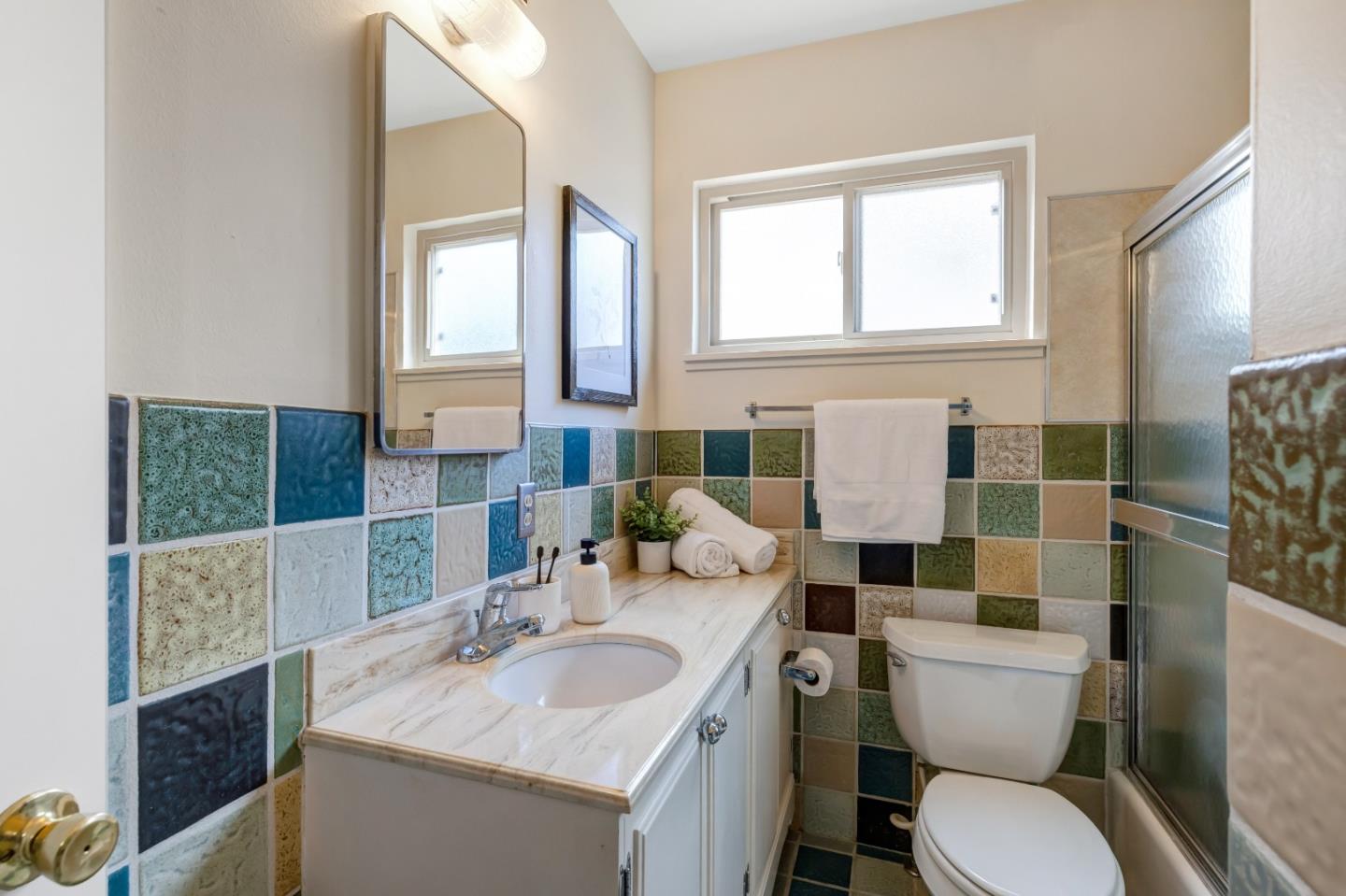 3370 Rio Road Carmel, CA 93923 - Photo 12 of 15 a bathroom with a toilet a sink and a mirror