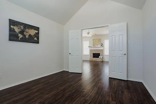 a view of a room with wooden floor and a kitchen
