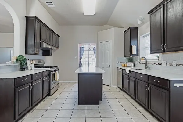 a large kitchen with granite countertop a sink and cabinets