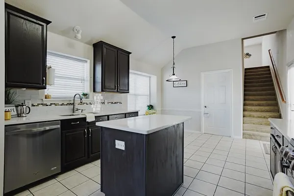 a kitchen with a sink appliances and cabinets