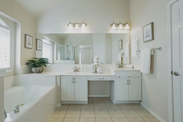 a spacious bathroom with a bathtub sink and mirror