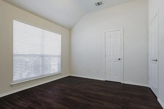 an empty room with wooden floor and a window