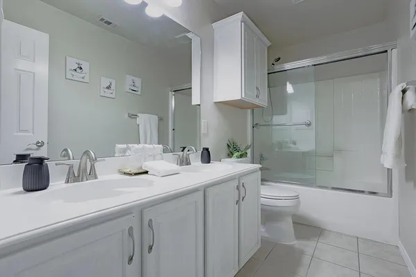 a bathroom with a double vanity sink toilet and shower