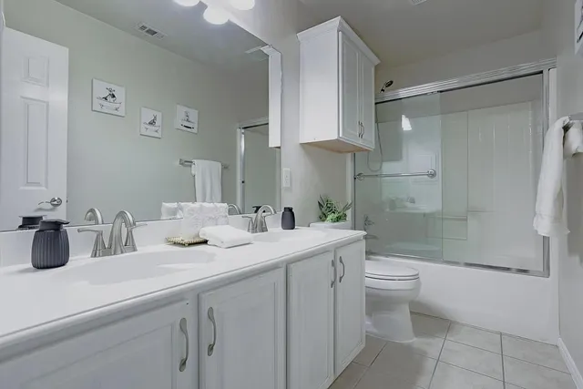 a bathroom with a double vanity sink toilet and shower