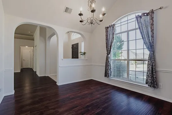 a view of a room with wooden floor and front door