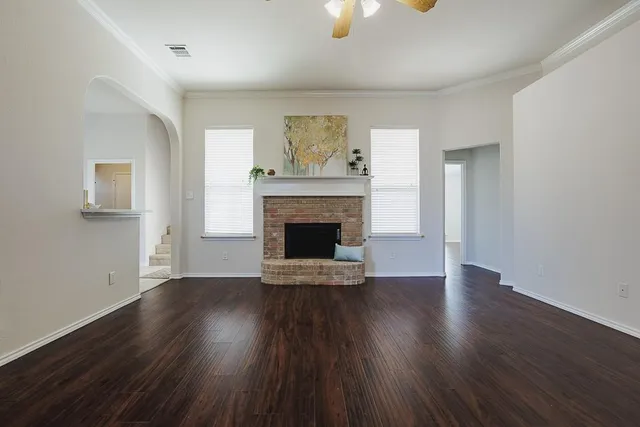 an empty room with wooden floor a fireplace