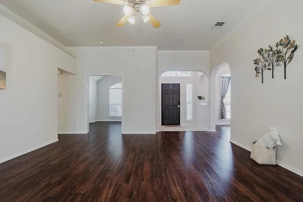 a view of an empty room with wooden floor