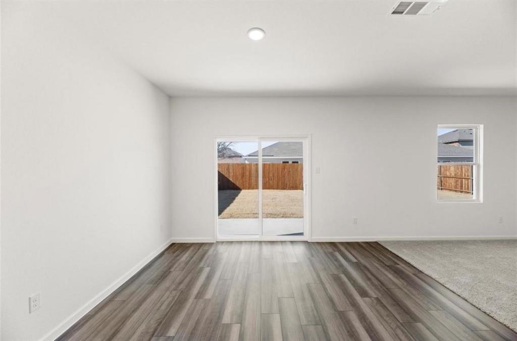 10308 Holy Cross Lane Crowley, TX 76036 - Photo 12 of 27 a view of an empty room with wooden floor and a window