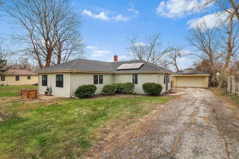 a front view of a house with yard and green space